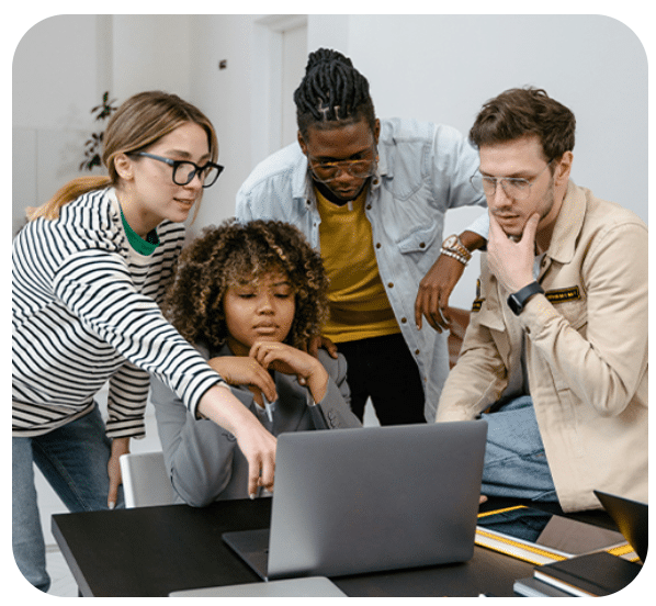 Quatre personnes collaborant devant un ordinateur portable.
